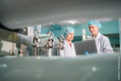 Two female lab workers look down// copyright: FoToArtist_1/envato